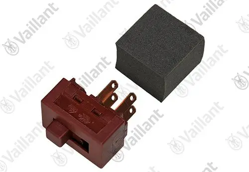Vaillant Schalter in roter Ausführung mit mehreren Anschlussklemmen und einem schwarzen Schaumstoffblock daneben.